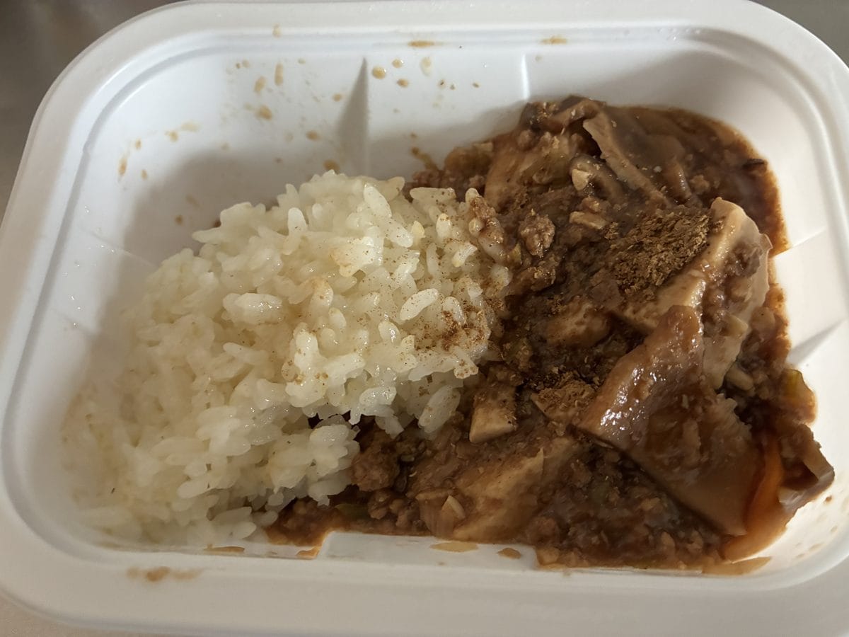つくりおき.jp（ツクリオ）の麻婆豆腐をごはんにかけて食べているところ。容器のままレンジで温めて食べられる
